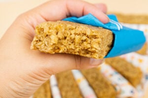 A flapjack being held by hand wrapped in a blue napkin